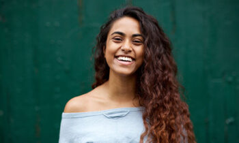 Image Text: 500x332_0003_front portrait of happy young Indian woman laughing against green background
